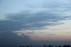 buio blu nube con bianca leggero tramonto cielo sfondo e città leggero mezzanotte sera tempo foto