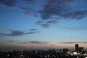 buio blu nube con bianca leggero tramonto cielo sfondo e città leggero mezzanotte sera tempo foto