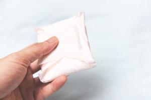 Tenere sanitario tovagliolo o femminile sanitario tampone su mano - femmina igiene si intende donne periodo Prodotto assorbente lenzuola foto