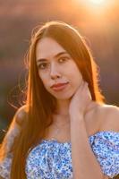 attraente snello contento ragazza nel un' blu vestito nel un' lavanda campo a tramonto. foto