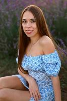 attraente snello contento ragazza nel un' blu vestito nel un' lavanda campo a tramonto. foto