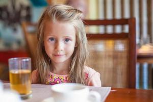 bambina che mangia prima colazione foto