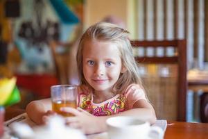 bambina che mangia prima colazione foto