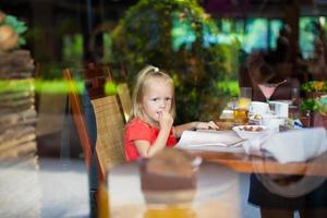 bambina che mangia prima colazione foto