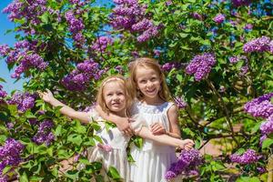 poco sorelle con fiori nel il giardino foto
