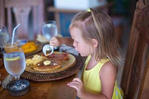 bambina che mangia prima colazione foto