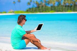 uomo con dispositivo di il spiaggia foto