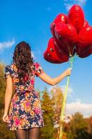 giovane donna con rosso cuore palloncini foto