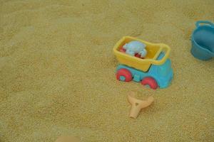 selettivo messa a fuoco su figli di camion giocattoli su sintetico sabbia fatto a partire dal semi, figli di campi da gioco. morbido messa a fuoco foto
