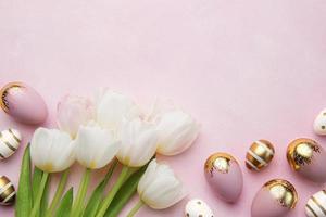 Pasqua d'oro uova e rosa tulipani su rosa sfondo. foto