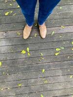 Da donna gambe nel un' semplice Marrone scarpe. superiore Visualizza di donna gamba indossare scarpe e magro blu jeans. semplice e strada moda. foto