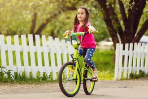 poco ragazza con sua bicicletta foto