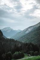 maestoso montagne nel il Alpi coperto con alberi e nuvole foto