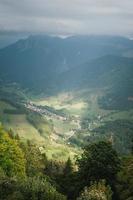 maestoso montagne nel il Alpi coperto con alberi e nuvole foto