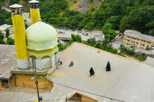 masule, iran, 2022 - donna nel tradizionale capi di abbigliamento camminare di moschea nel masouleh montagne villaggio. gilan Provincia foto