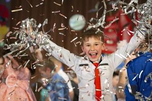 contento poco ragazzo nel coriandoli.magia tempo - ritratto di un' molto contento bambino con mani sorridente mentre caduta coriandoli. a un' figli di festa o compleanno. foto