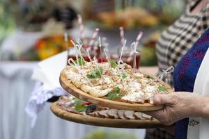 nel il mani di un' vassoio con carne spuntini per un' buffet tavolo o degustazione. foto