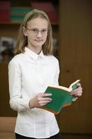 ragazza scolara con un' libro. mezzo scuola età. foto