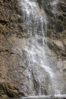 bellissimo cascata nel il montagne. acqua flussi giù a partire dal il montagne. foto
