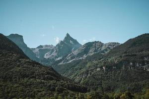 maestoso montagne nel il Alpi coperto con alberi e nuvole foto