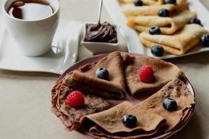 classico e cioccolato Pancakes con frutti di bosco e frutta per colazione, cioccolato, Tè, foto