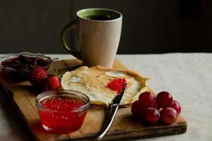 pancake con rosso caviale per colazione, un' tazza di tè foto