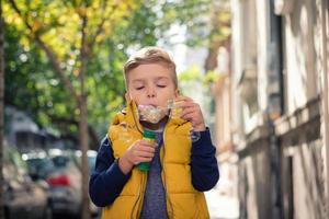 poco ragazzo soffiaggio bolle con bolla bacchetta. foto