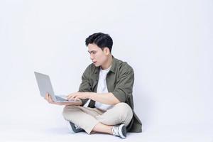 giovane asiatico attività commerciale uomo seduta e utilizzando il computer portatile su sfondo foto