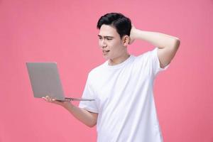 giovane asiatico uomo Tenere il computer portatile su sfondo foto