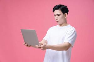 giovane asiatico uomo Tenere il computer portatile su sfondo foto