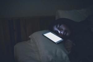 asiatico donna giocando gioco su smartphone nel il letto a notte, Tailandia persone, tossicodipendenti sociale media foto