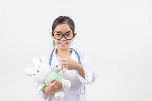 Asia poco ragazza giocando medico isolato su bianca foto