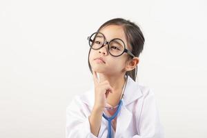 Asia poco ragazza giocando medico isolato su bianca foto