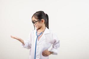 Asia poco ragazza giocando medico isolato su bianca foto