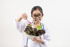 Asia poco ragazza giocando medico isolato su bianca foto