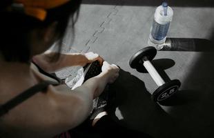 donna che lega i lacci delle scarpe. Close up del corridore di fitness sport femminile si prepara per fare jogging in palestra foto