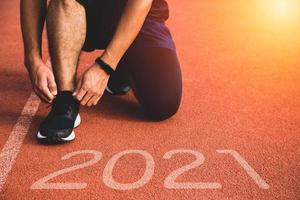 nuovo anno o iniziare il concetto dritto. primo piano di un corridore atleta che corre verso il successo e nuovi risultati sul percorso con iscrizione 2021 foto