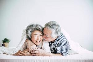 felice coppia senior ridendo in camera da letto foto