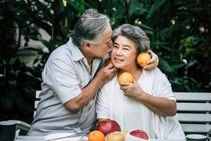 coppia di anziani giocando e mangiando un po 'di frutta foto