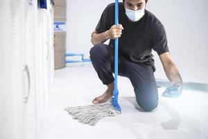 uomo asiatico che pulisce il pavimento foto