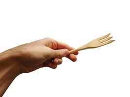 mano che tiene la forchetta di legno isolato in uno sfondo bianco foto
