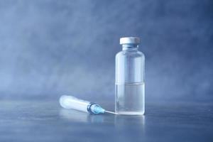 Close up di un vaccino e una siringa su sfondo nero
