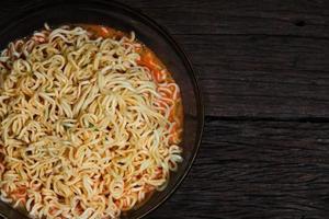 spaghetti istantanei in una ciotola su fondo in legno foto