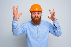 isolato contento architetto con barba e arancia casco foto