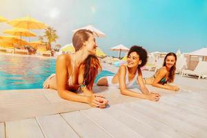 gruppo di amici nel costume da bagno godere nel un' nuoto piscina foto