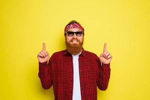 contento uomo con barba e bandana nel testa grida indica qualcosa foto