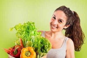 bellissimo ragazza con verdure nel il Borsa. verde stile foto