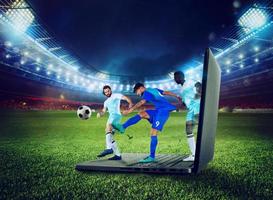 calcio Giocatori giocare su un' computer portatile, concetto di tv streaming foto