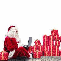 tecnologico Santa Claus seduta con il computer portatile acquista Natale i regali con e-commerce foto