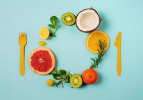 composizione di agrume frutta, arancia e Limone, noce di cocco, Kiwi su ciano sfondo foto